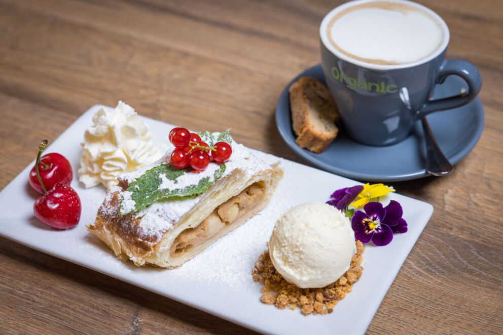 Bezuckerter Apfelstrudel mit einer leckeren Kugel eis und Kirschen